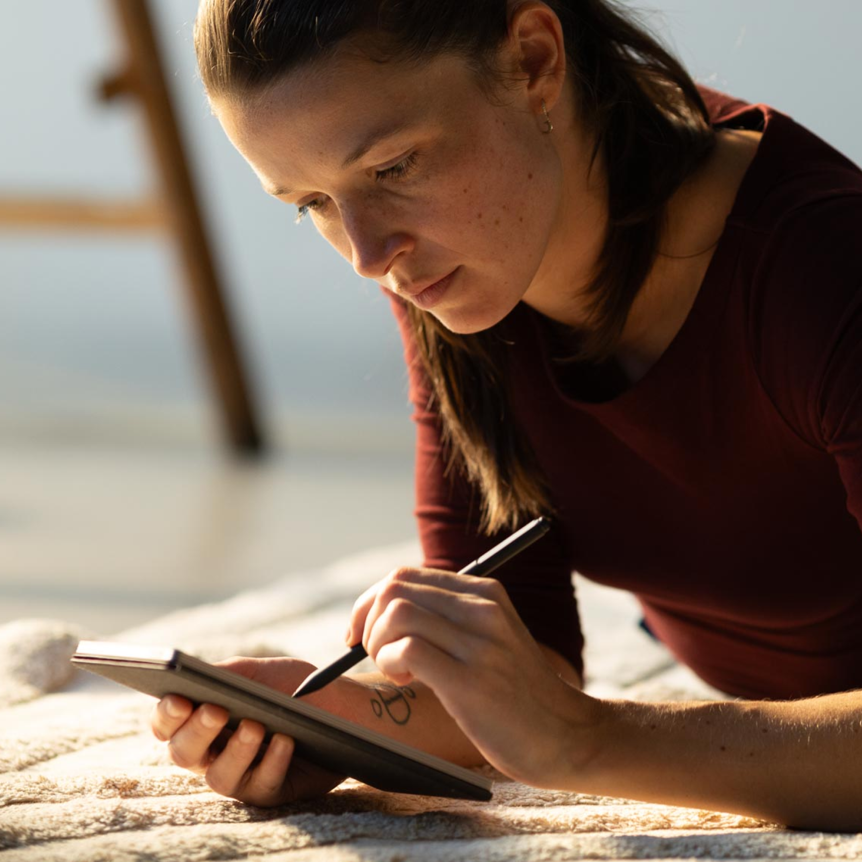 A young woman in deep focus writing on the reMarkable Paper Pro Move