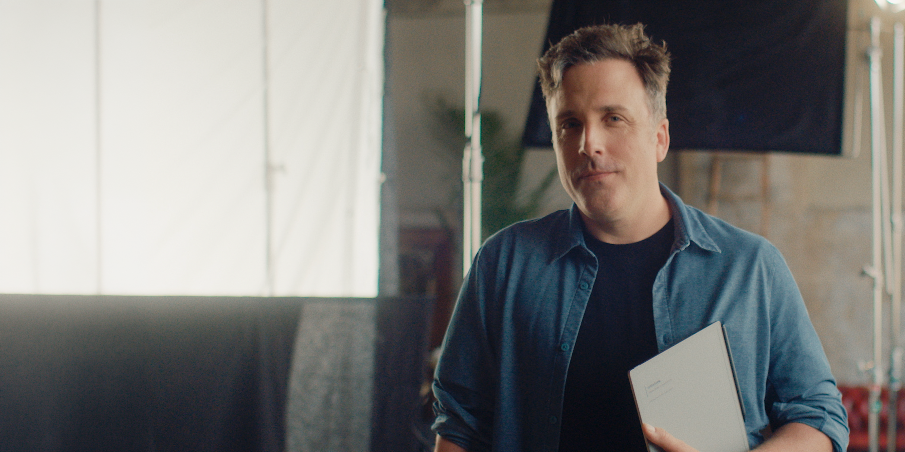 A creative holding his reMarkable Paper Pure.