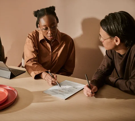 A group of people sitting together in a meeting and having discussion over a reMarkable Paper Pro.
