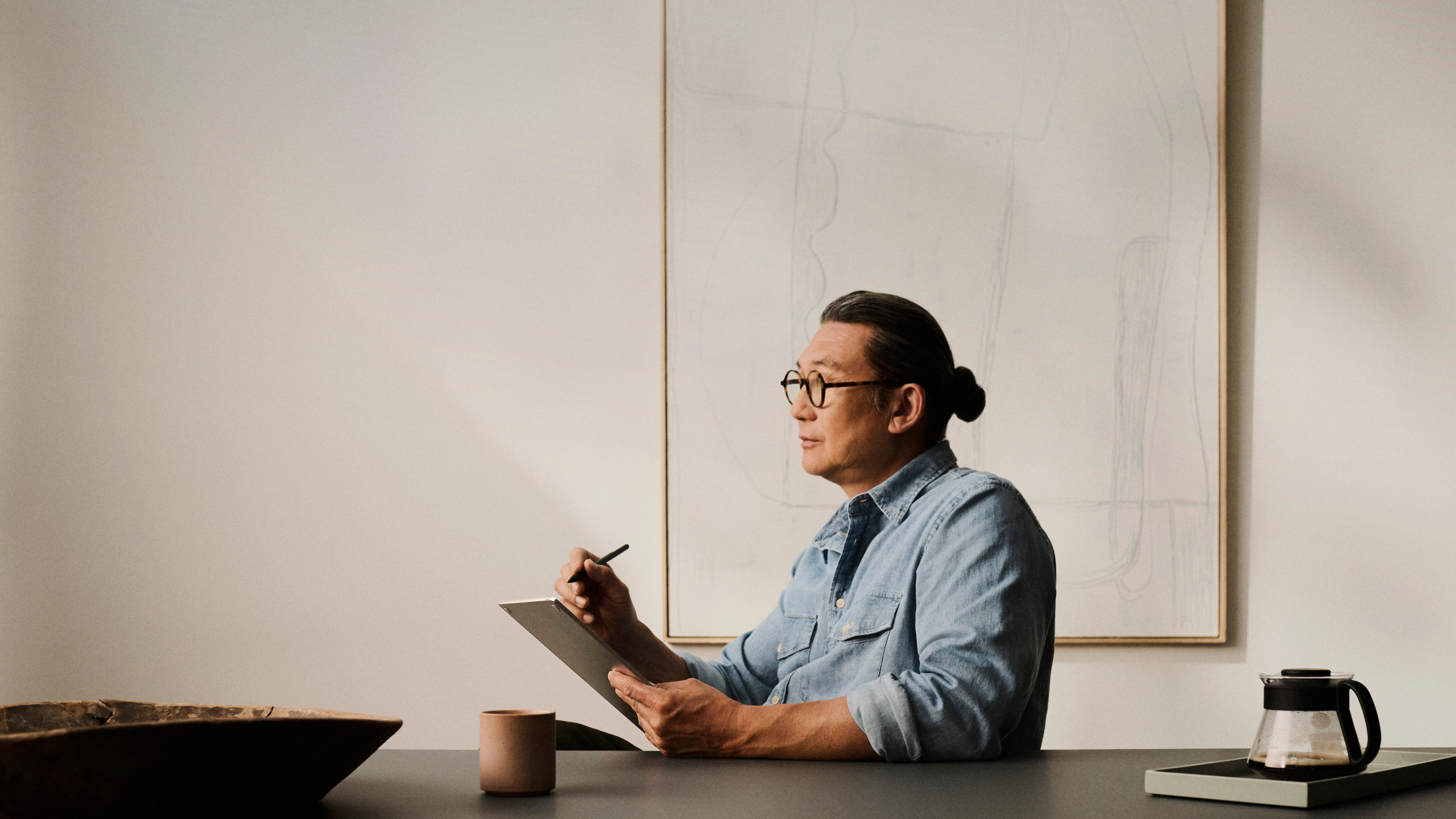 Person writing on a reMarkable Paper Pro with Marker Plus at a table.