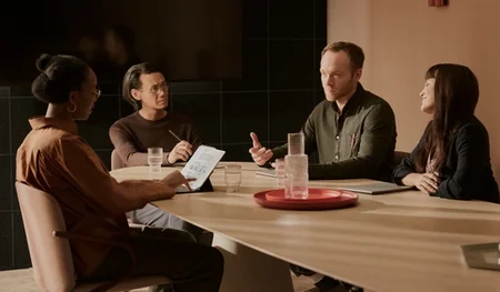 Four people in a meeting discussing while using the reMarkable Paper Pro