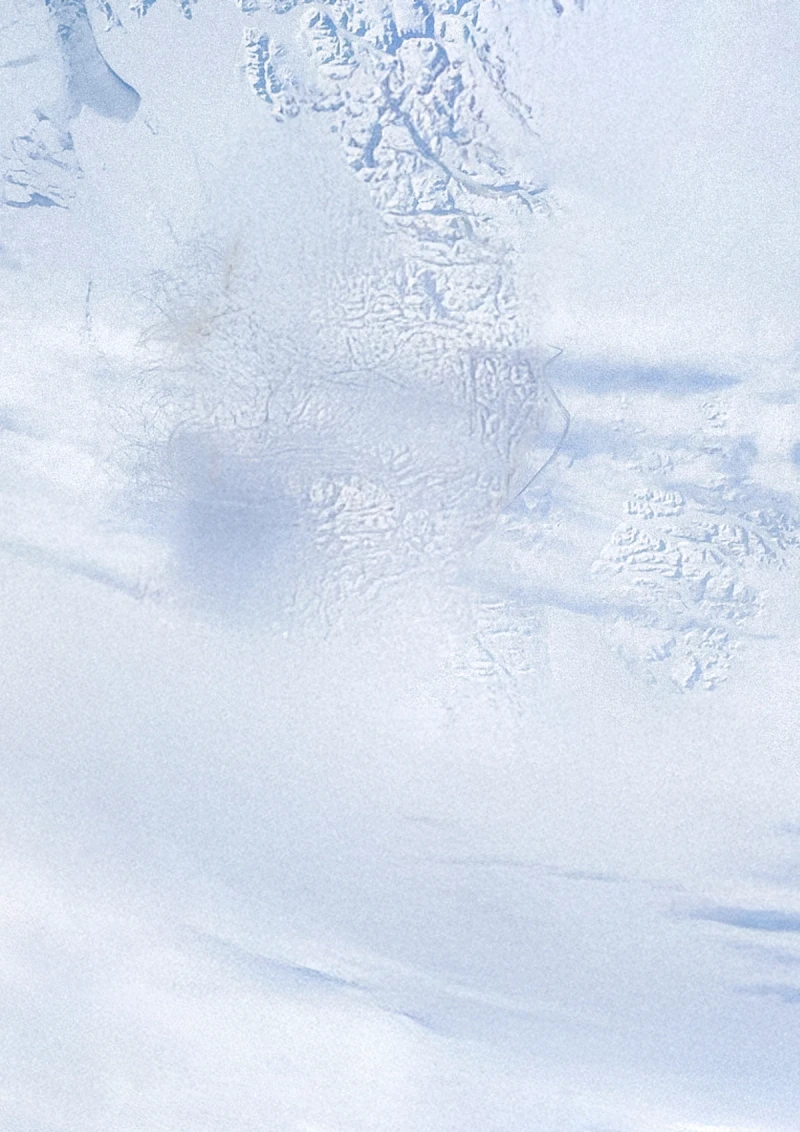 A polar region of the earth as seen from space, with snowy mountains and cloud cover.