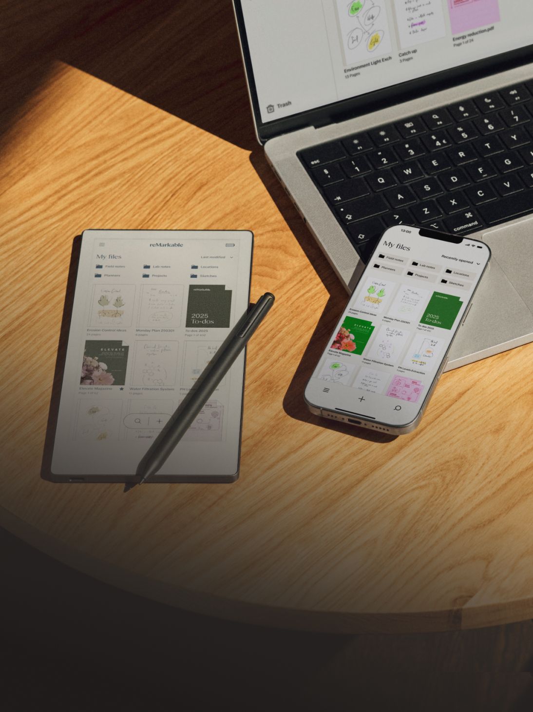 Paper tablet and a phone lying on a desk beside a computer.