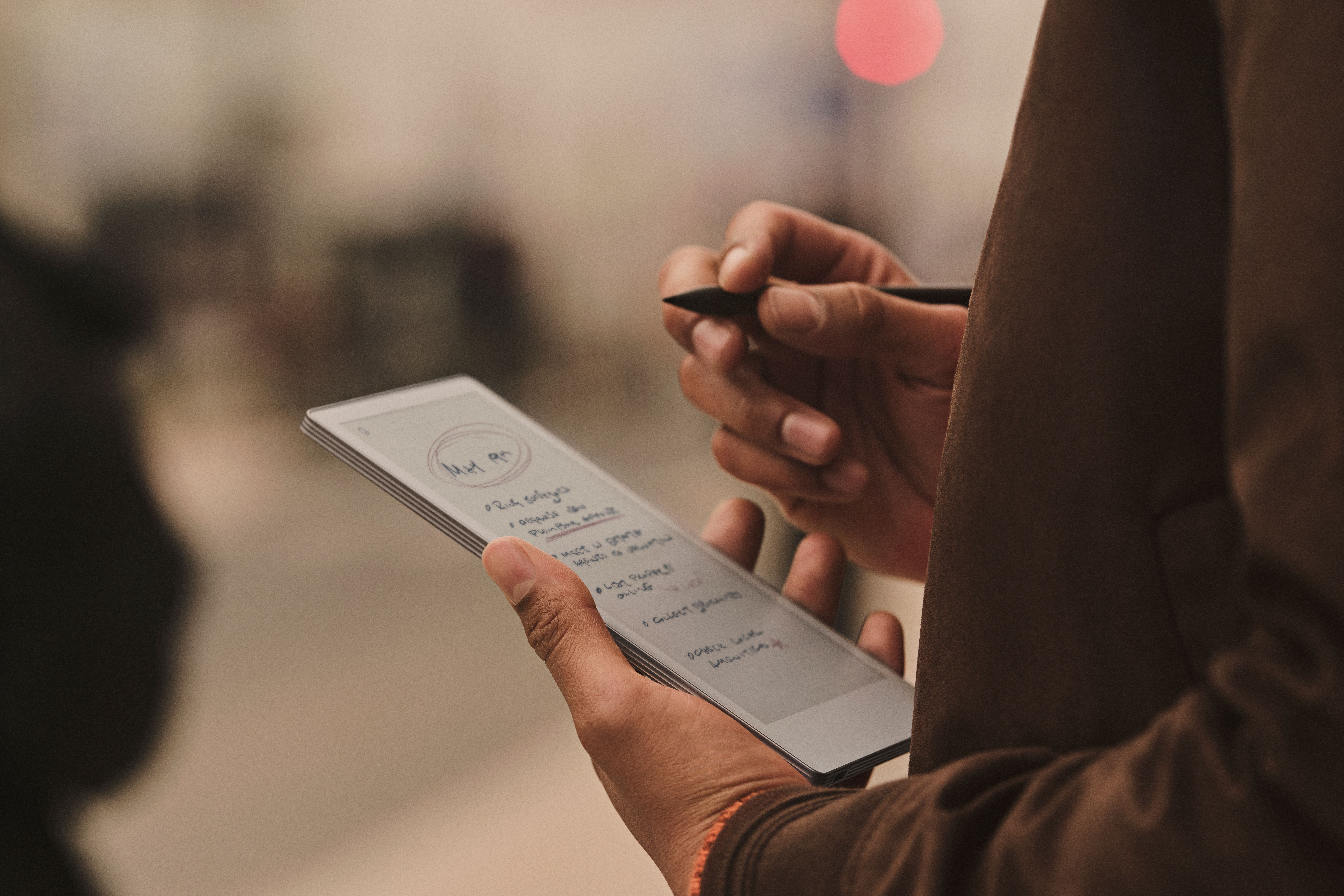 reMarkable Paper Pro Move tablet with handwritten notes and the Marker in use.