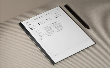 A reMarkable paper tablet displaying a file management interface next to its Marker.
