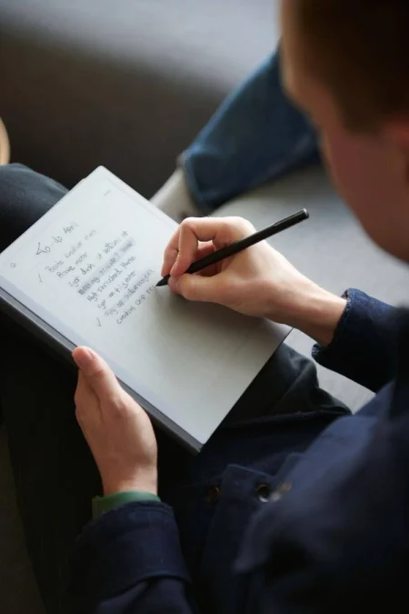 A reMarkable paper tablet showing a to-do list, being written on with the Marker.
