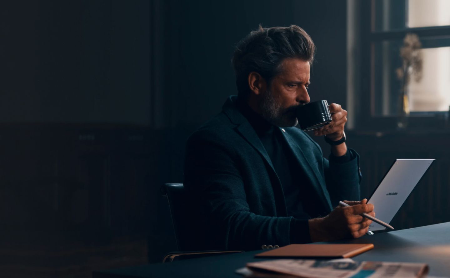 Man drinking coffee while using reMarkable paper tablet with Marker.