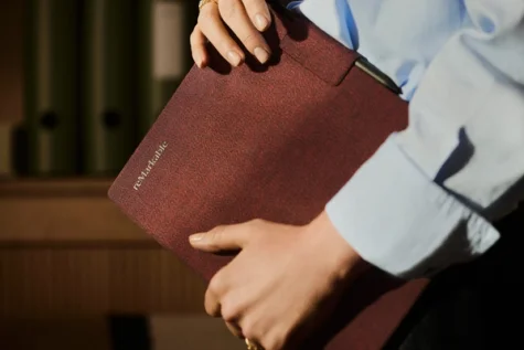 Someone carrying the reMarkable Paper Pro in a burgundy Mosaic Weave folio
