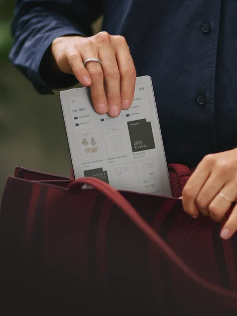 A reMarkable Paper Pro Move tablet being placed in a red handbag.