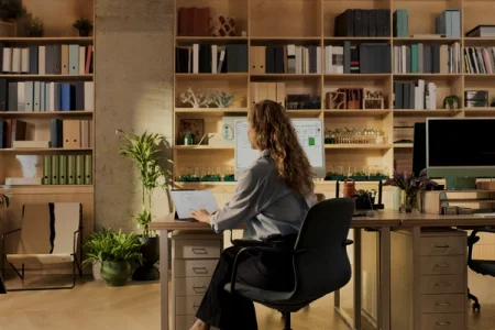 A woman sitting at a desk working with a laptop.