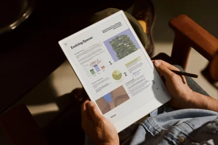 Person reviewing "Evolving Spaces" document on reMarkable paper tablet, and annotating with the Marker Plus.