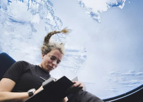 Jannicke Mikkelsen writing notes on a reMarkable paper tablet in zero gravity.