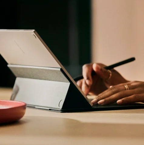 A woman writing and typing on her reMarkable Paper Pro using a Type Folio