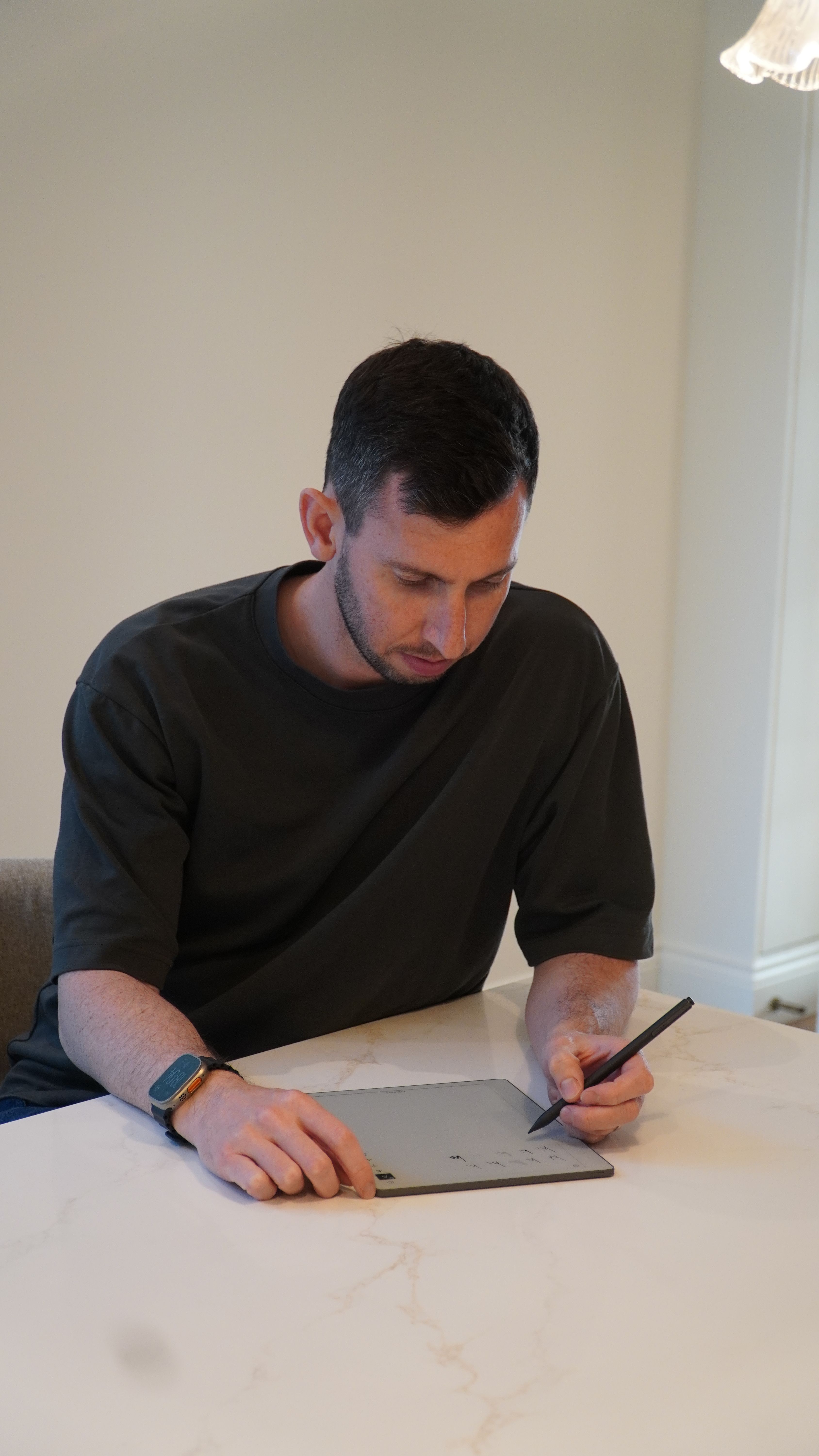 Gabriel Nussbaum sitting down at a table to work on his reMarkable Paper Pure. 