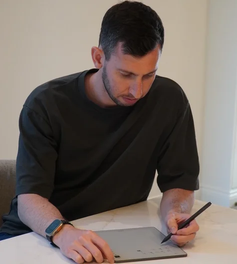 Gabriel Nussbaum sitting down at a table to work on his reMarkable Paper Pure.