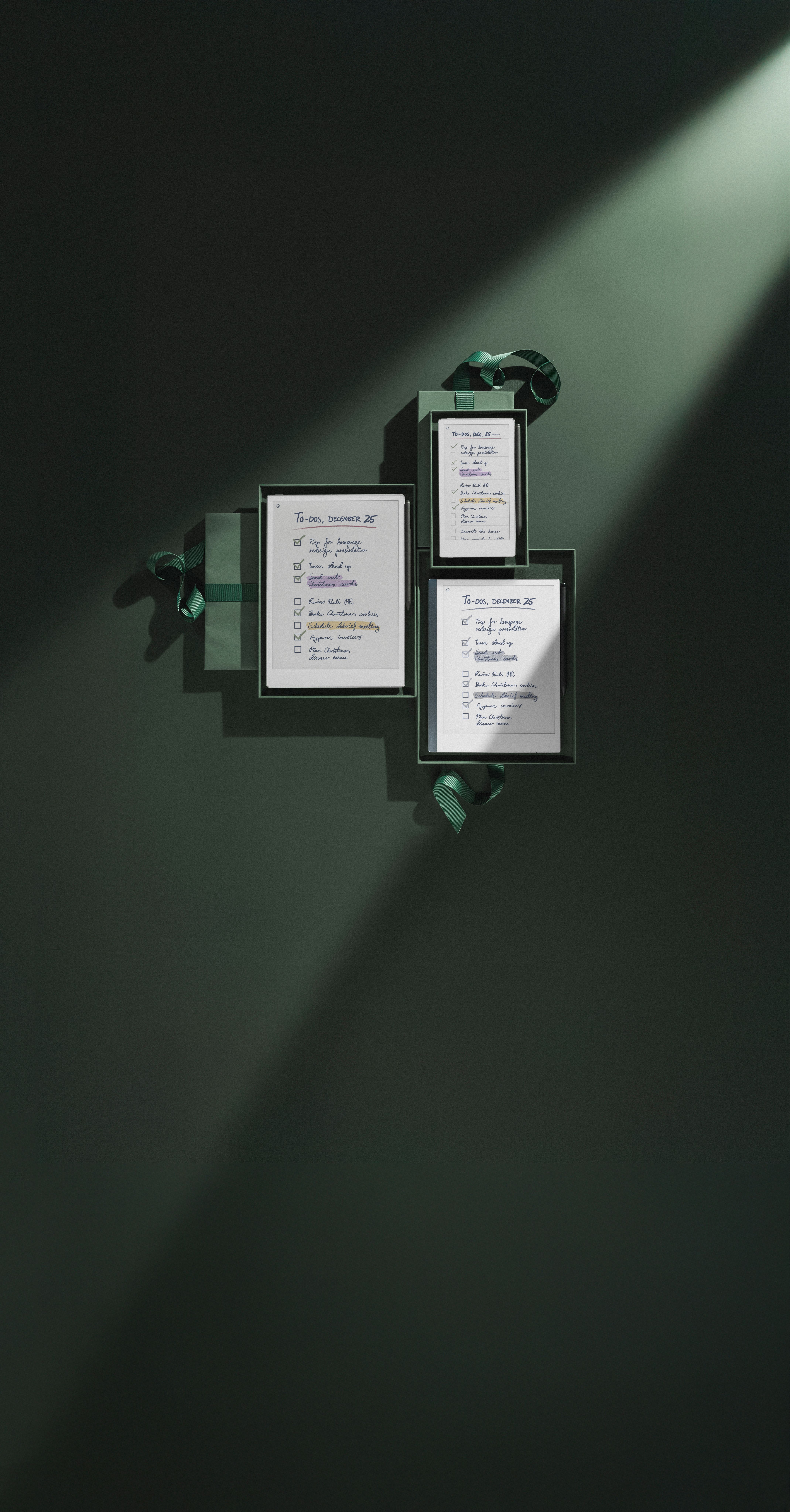 reMarkable Paper Pro, reMarkable Paper Pro Move and reMarkable 2 all gift wrapped in dark green paper, displaying TO DO lists for December 25th .