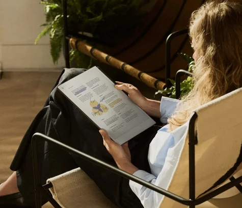 A woman reading a document that has been marked up and annotated with colored highlights on reMarkable Paper Pro.