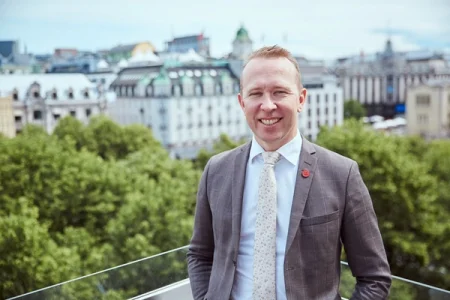 Sverre Haugen, Partner and Head of Innovation at MeyerHaugen stands with green trees and buildings in the background.