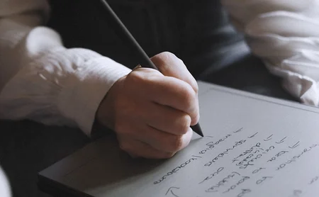 A hand writing notes on the reMarkable paper tablet with the Marker.
