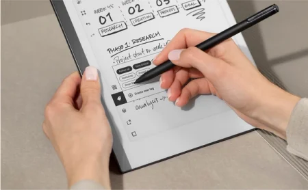 A reMarkable paper tablet displaying how tags work, as a hand navigates with the Marker.