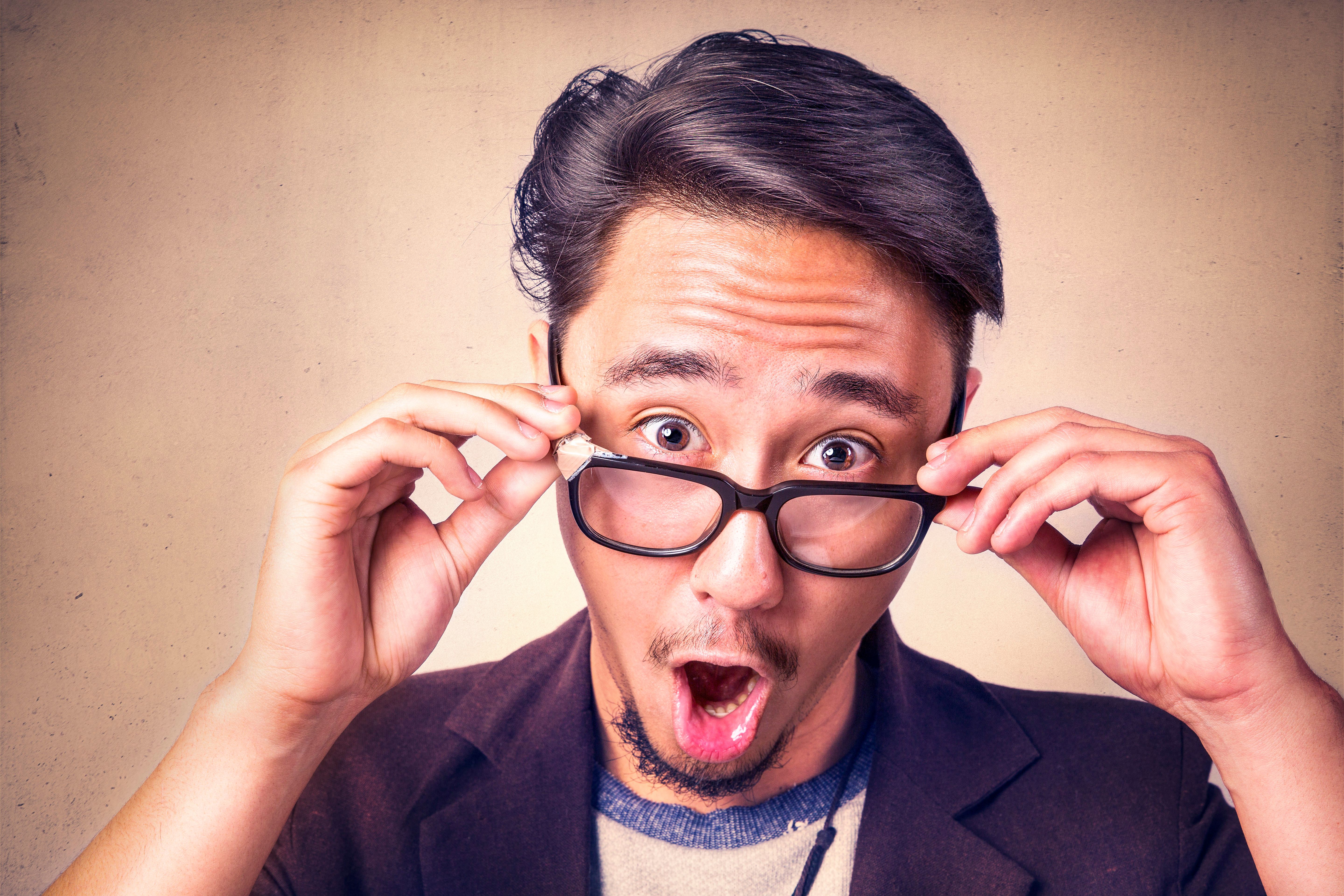 Man looking in surprise over his glasses