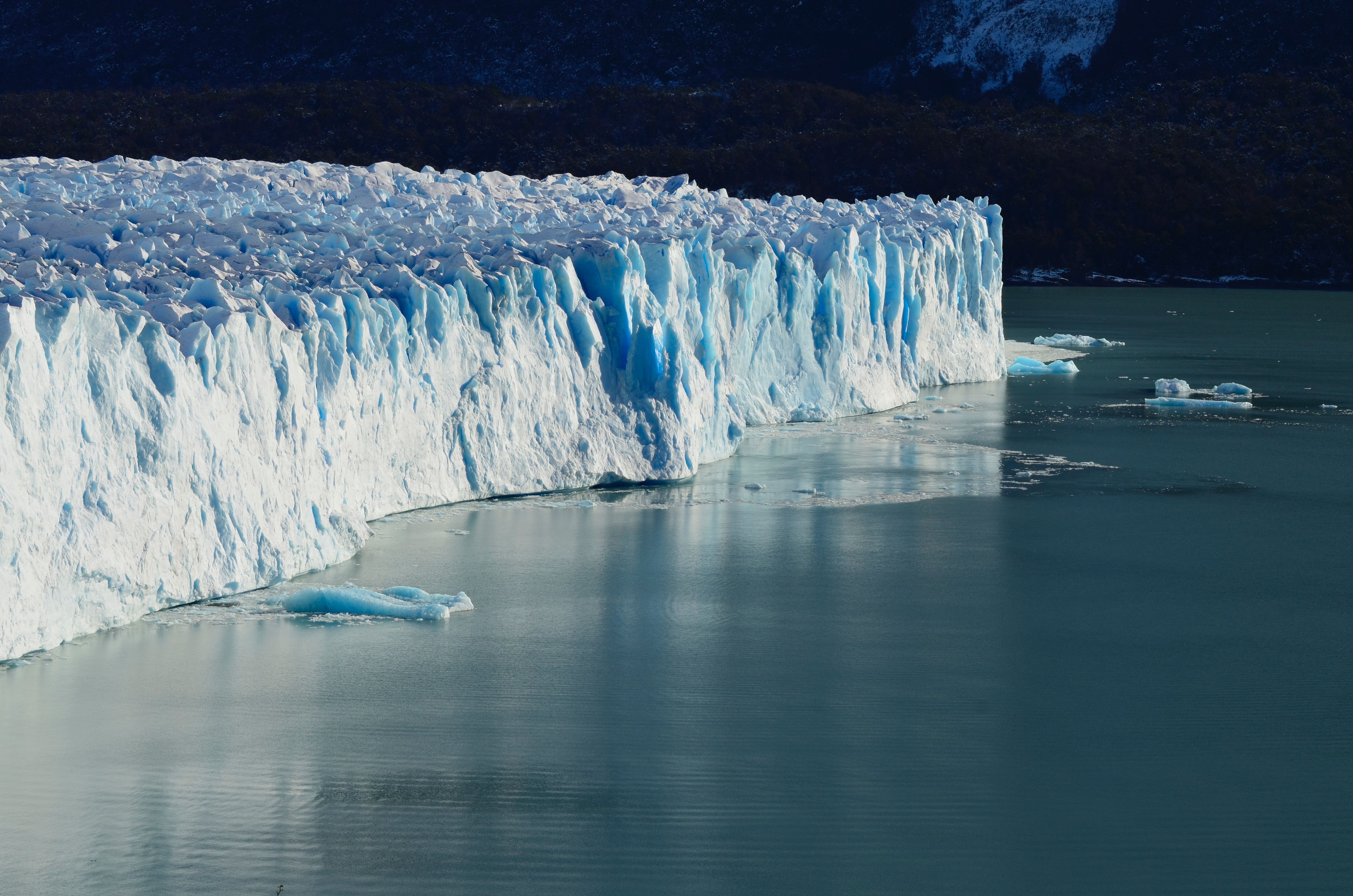 A large white and blue iceberg floating on the ocean.