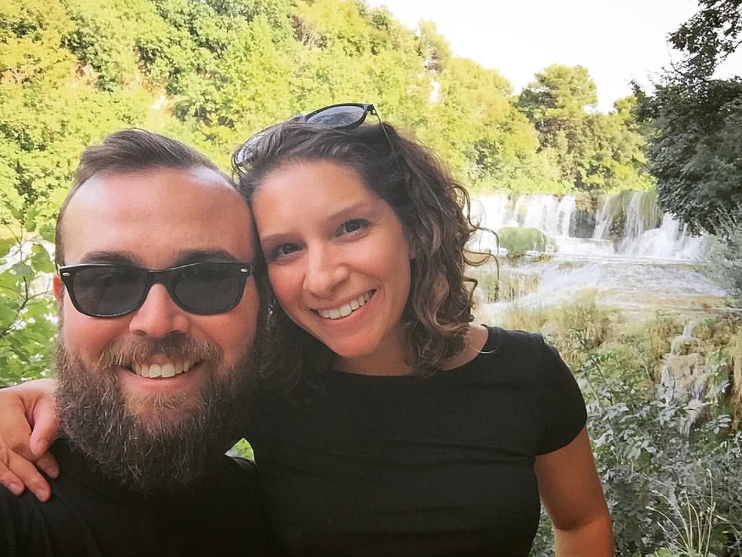 Jason and Marisa standing in front of a waterfall in Krka, Croatia