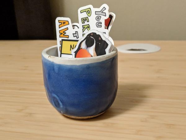 Small blue cup I made that is holding several stickers
