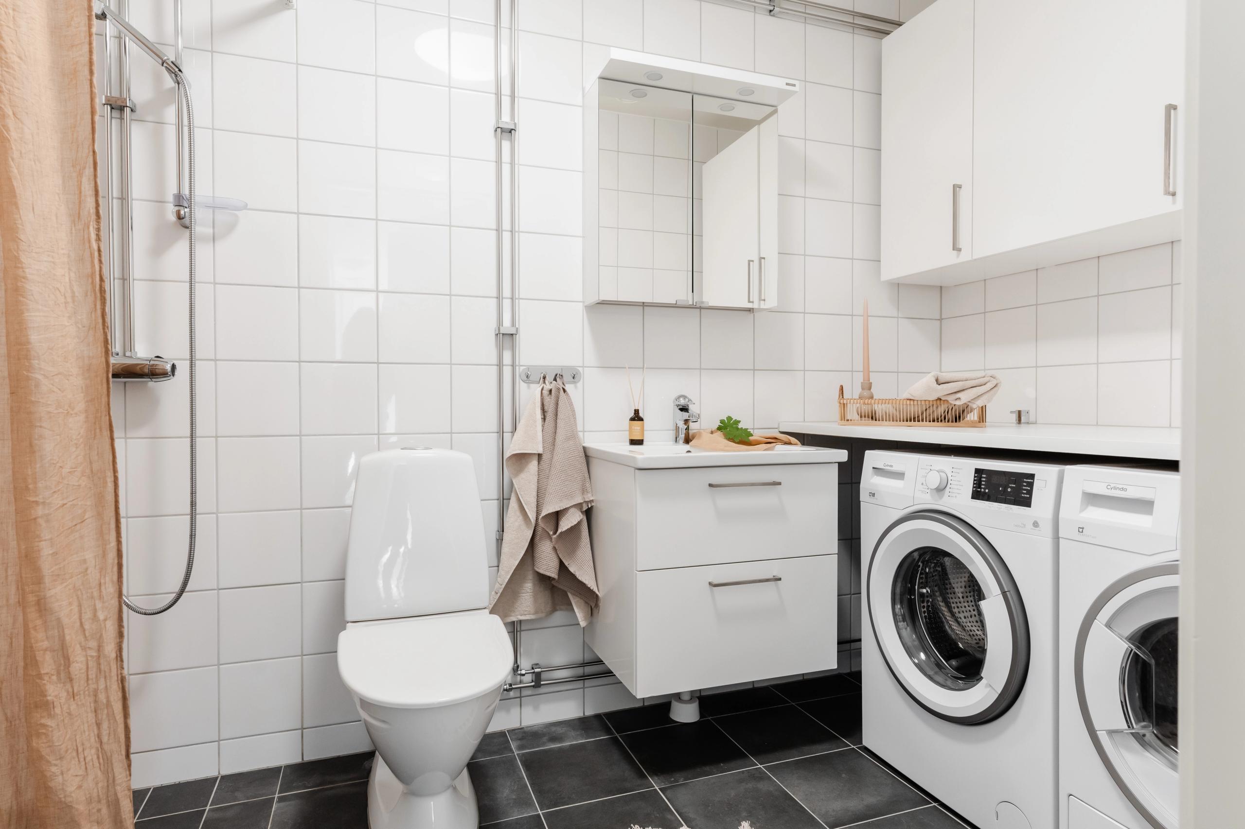 bathroom with shower, washing machine, tumble dryer