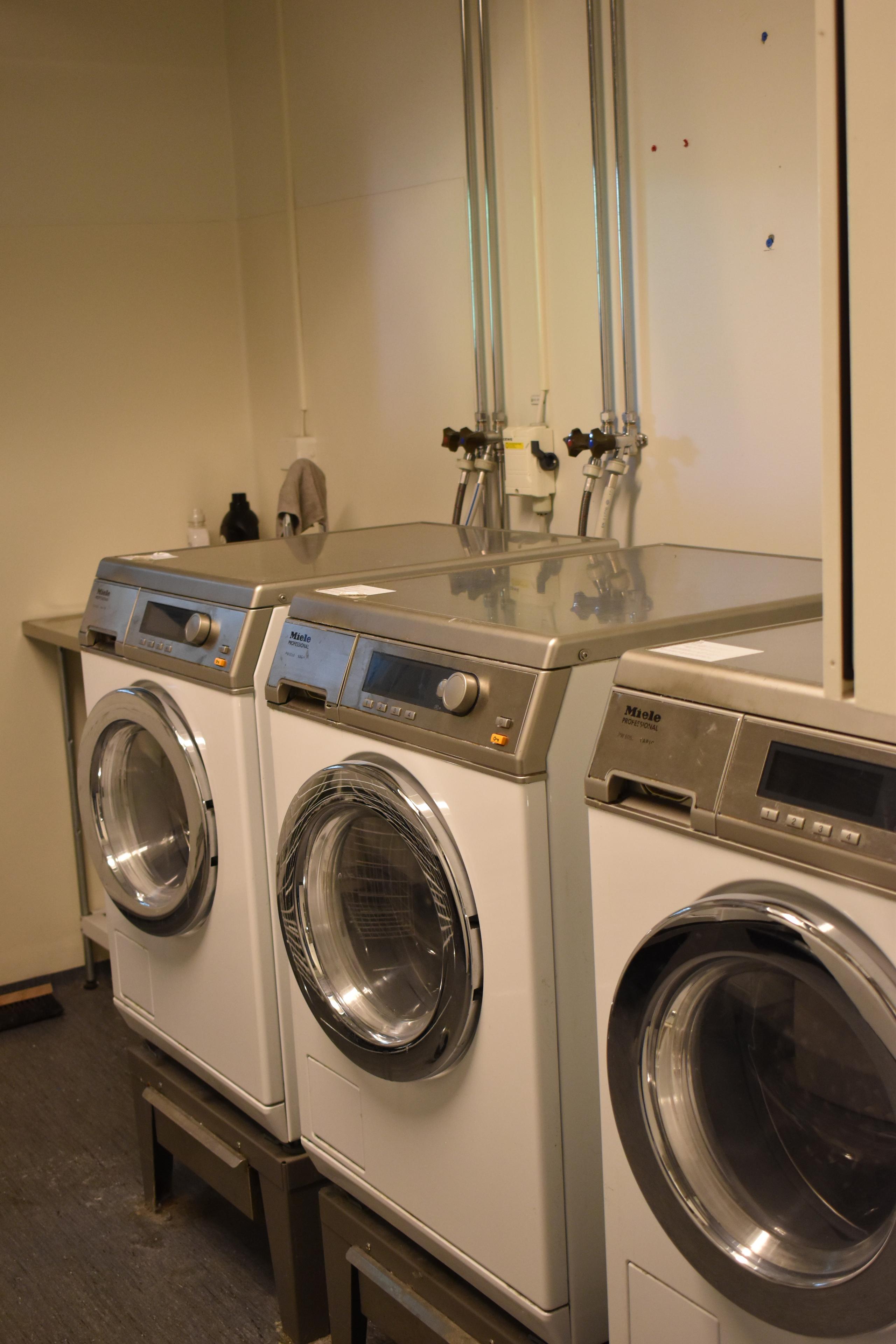 Student corridor. Laundry room with three washing machines in a row.
