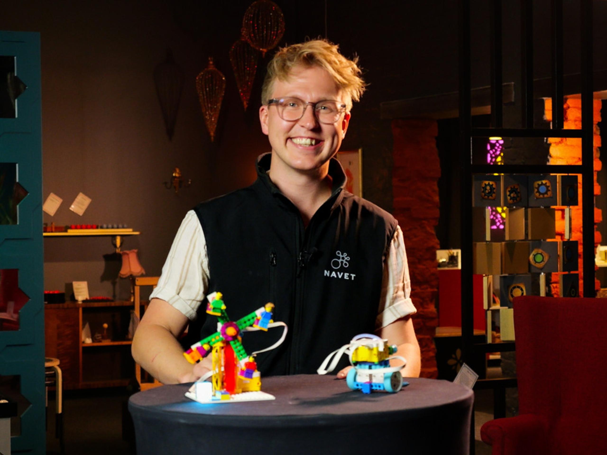 A man standing in front of a table with Lego on it.