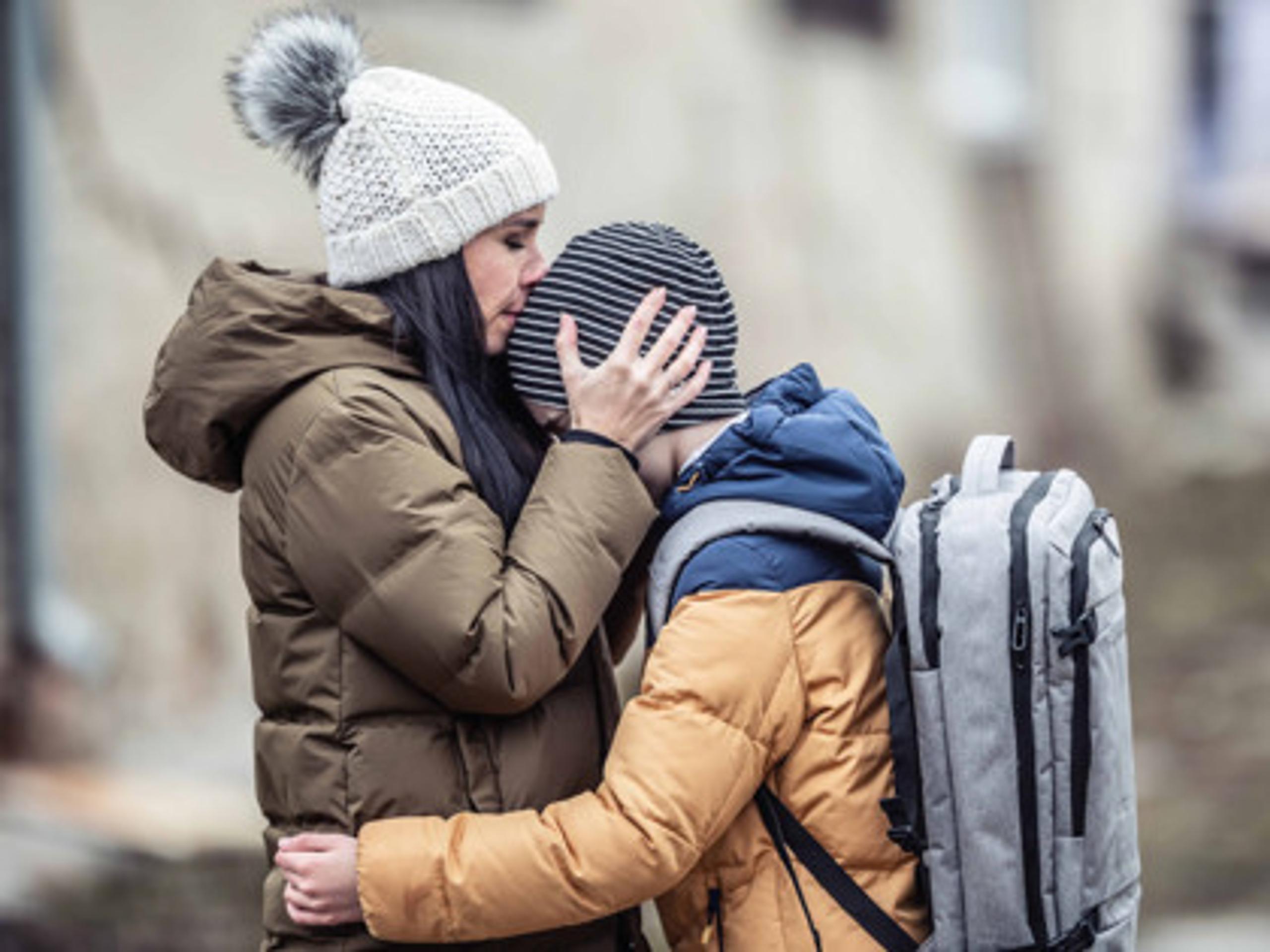 Woman kissing her son on the head in an autumn setting
