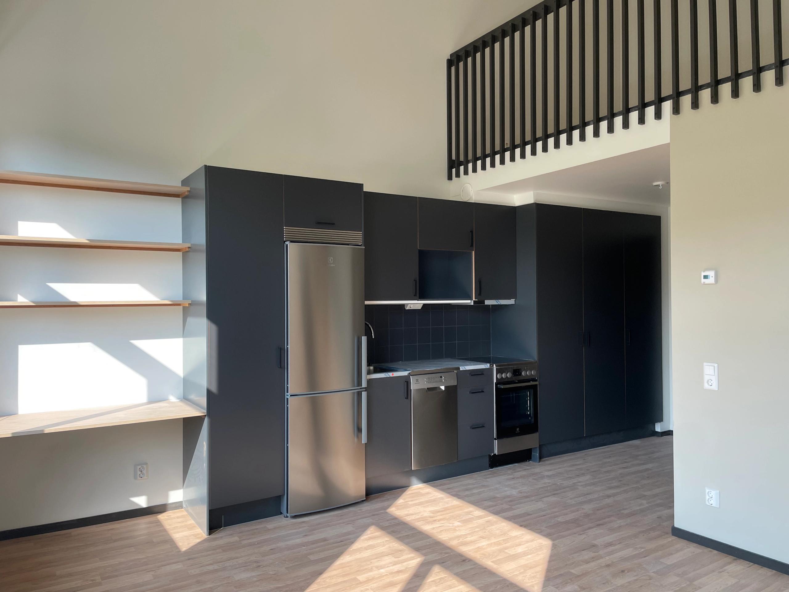 A kitchen with stainless steel appliances and a wooden floor.