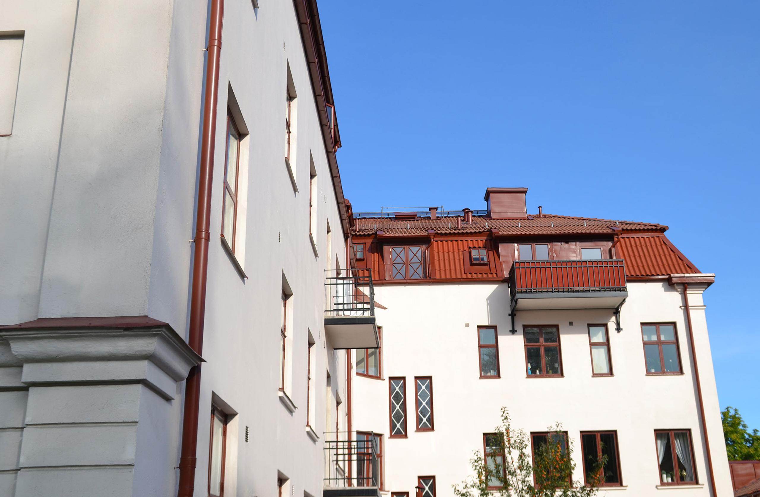 Tall white building with a red roof.