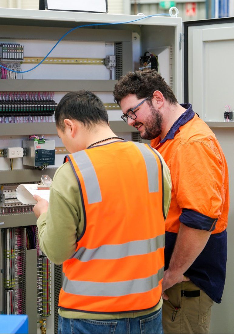 Metroid engineers working on an industrial control switchboard