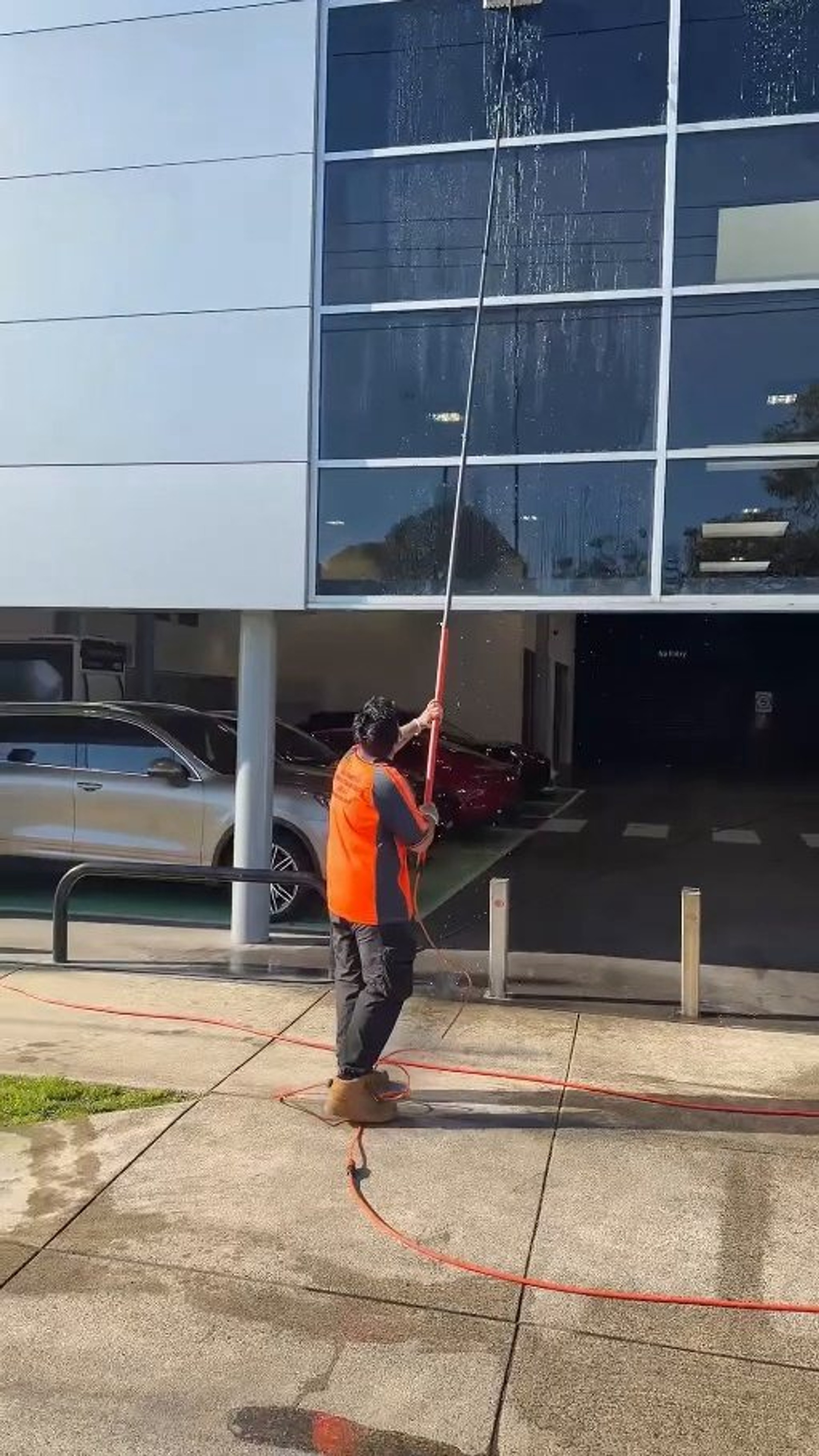 High-reach water-fed pole cleaning second-storey commercial windows