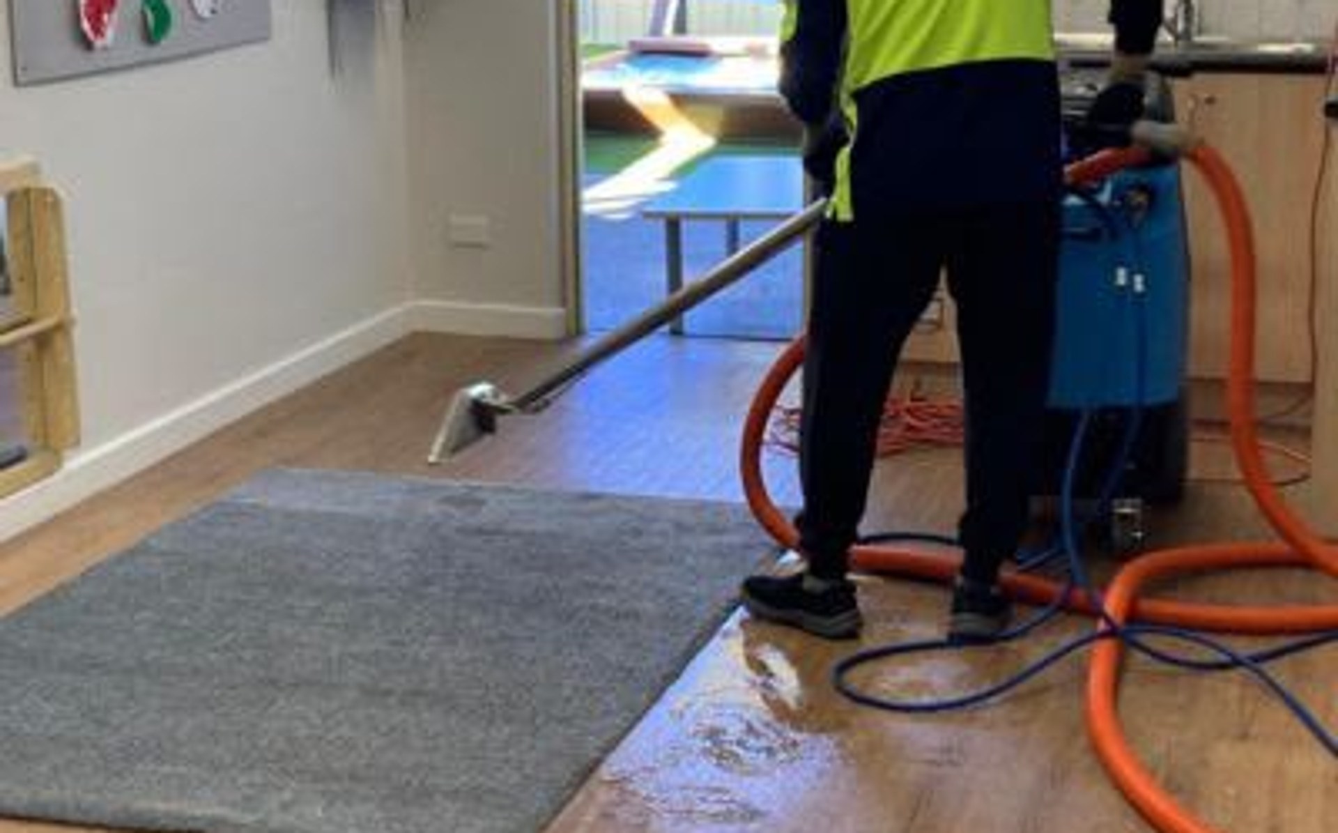 Cleaner using a floor machine in a childcare classroom