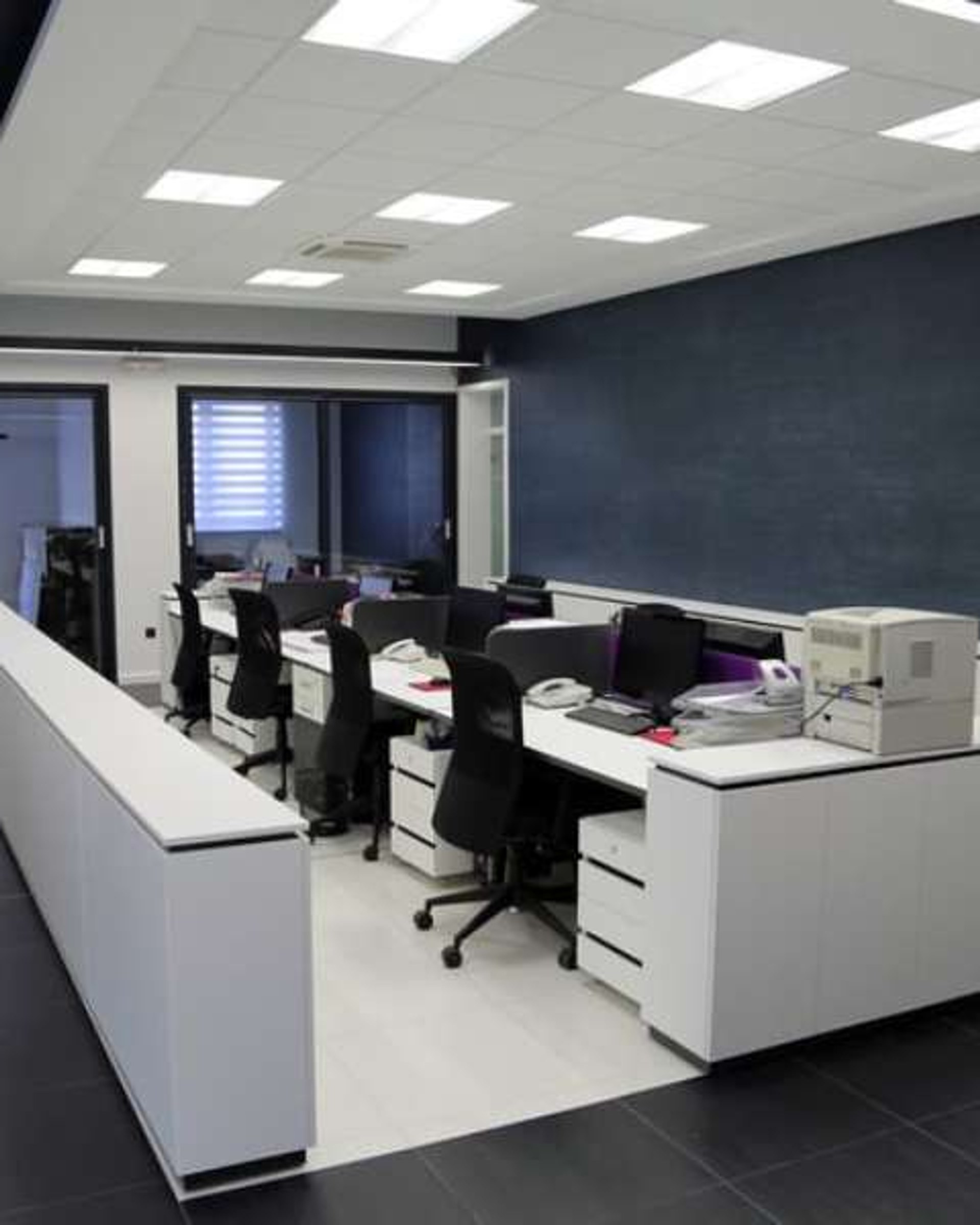 Modern open-plan corporate office with desks and meeting rooms