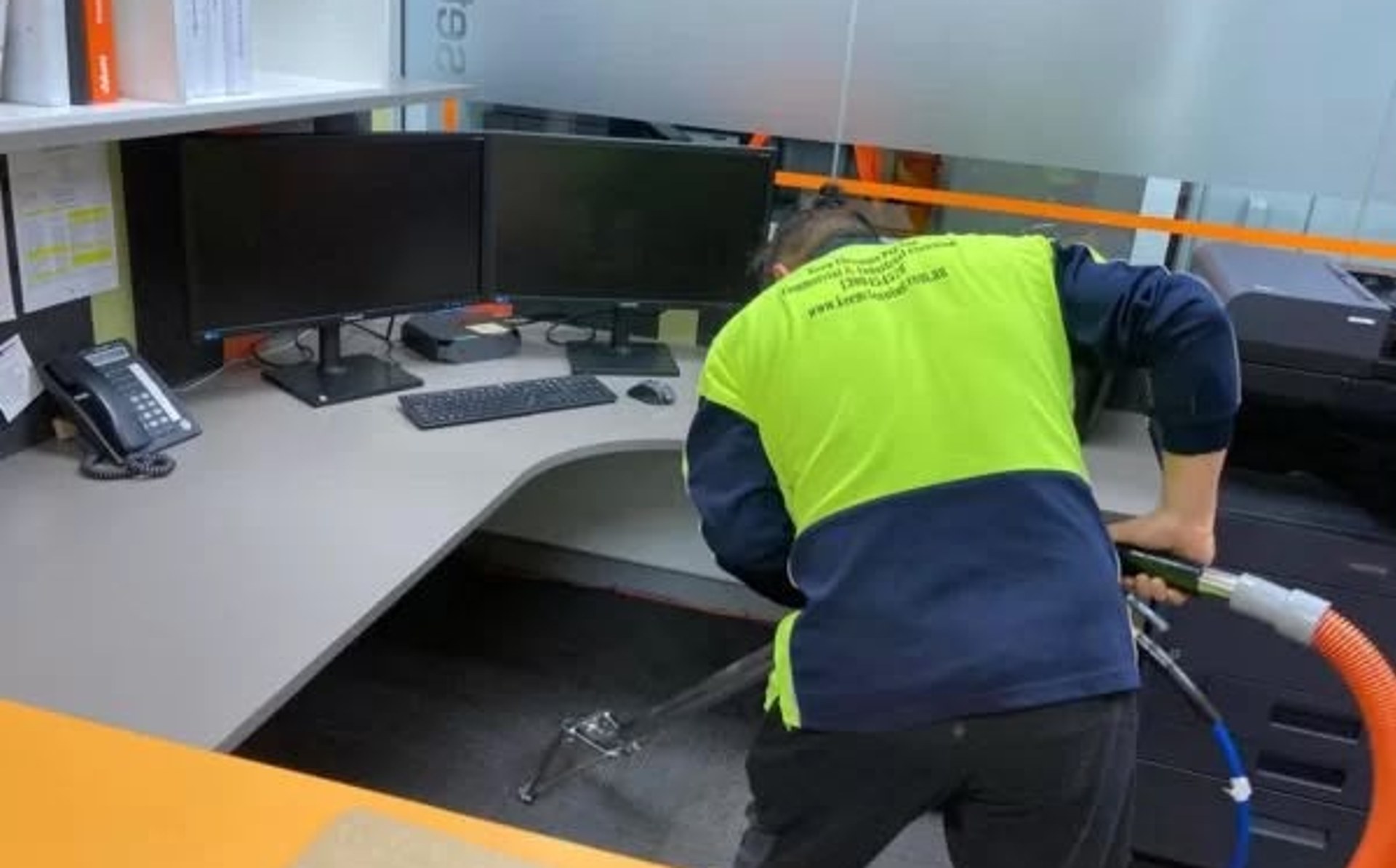 Technician cleaning carpet in an office workspace