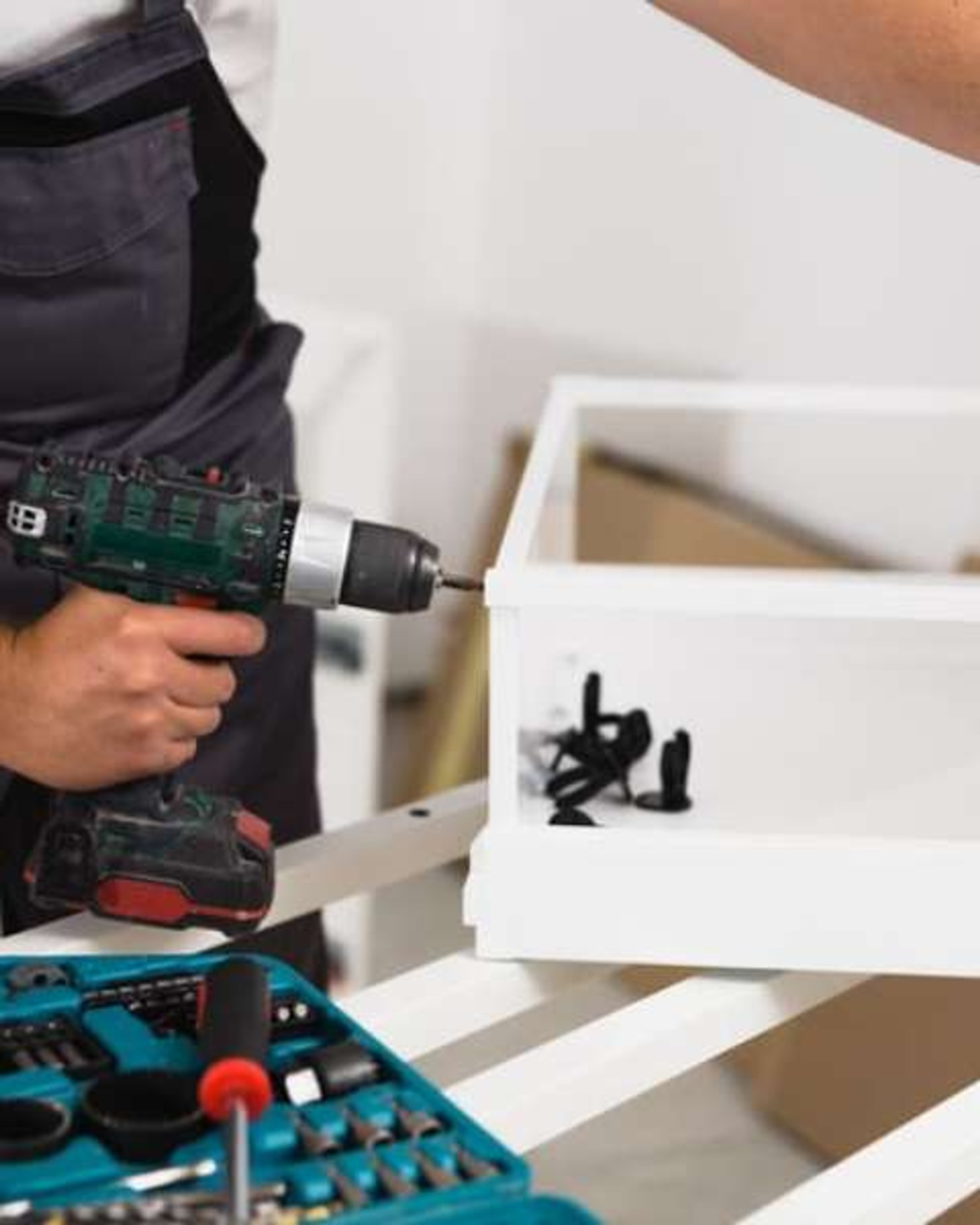 Professional handyman fixing a wall with power tools