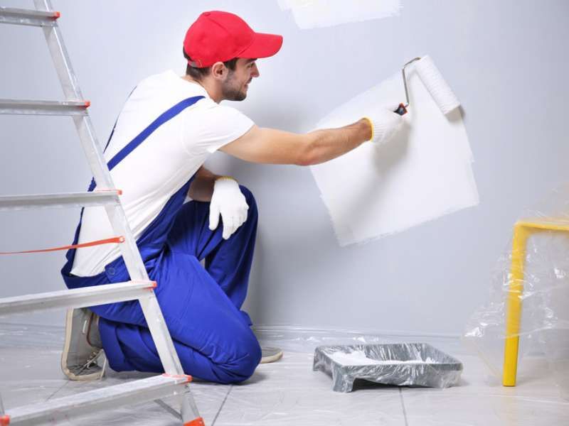 Painter using roller on freshly prepared wall