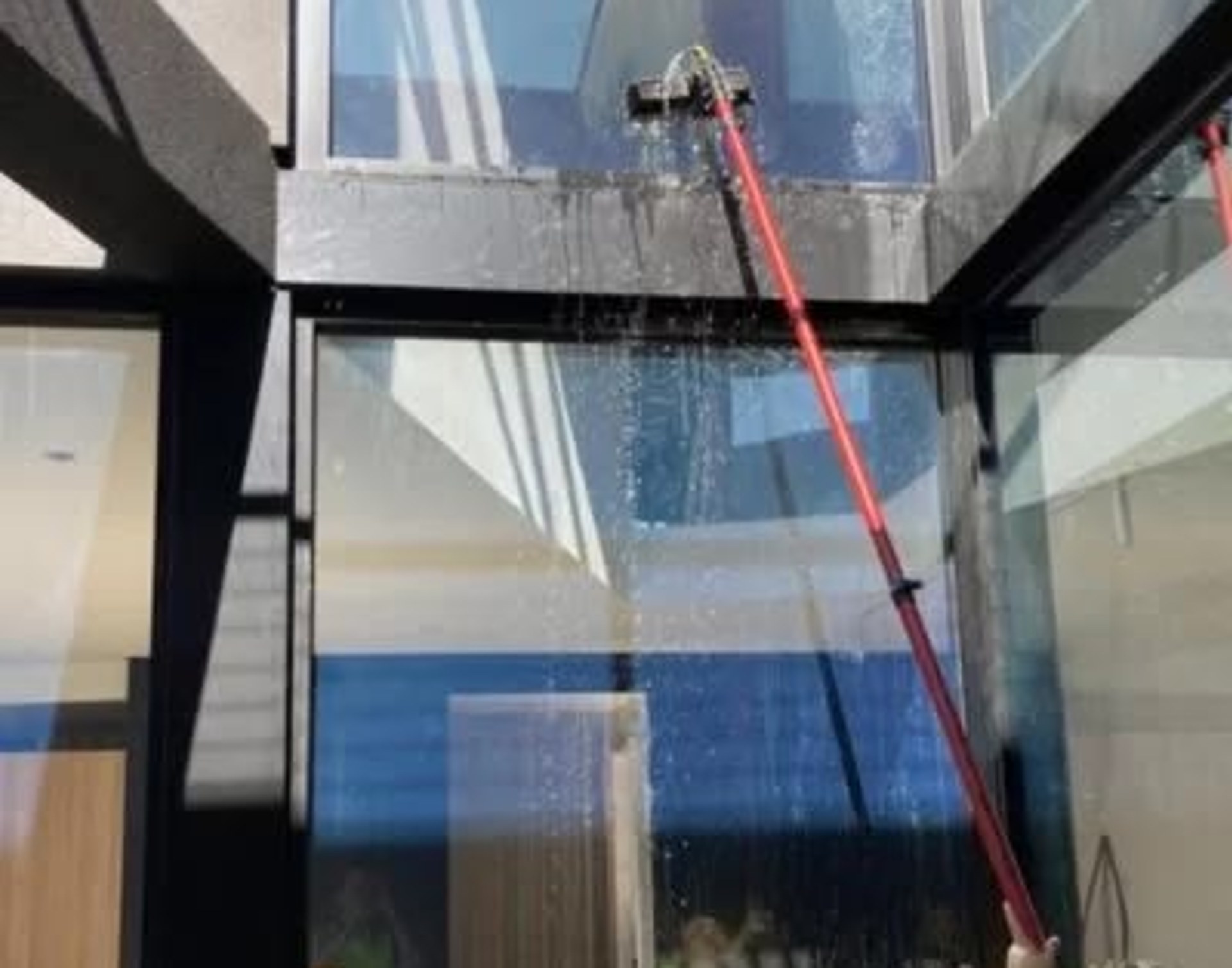 Window cleaner using a water-fed pole on commercial glass