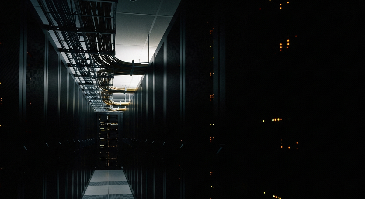 Long-exposure photograph of fibre cabling and server status lights in a data centre — automation infrastructure