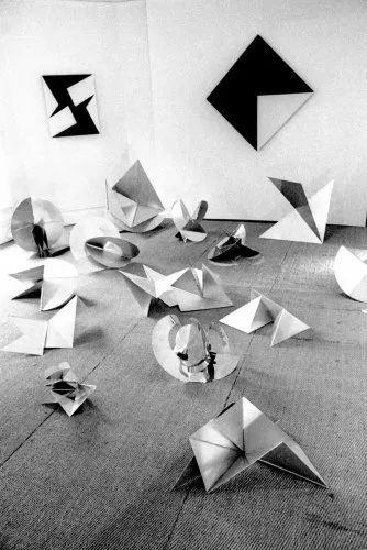 Composición de figuras geométricas plegadas en blanco y negro.