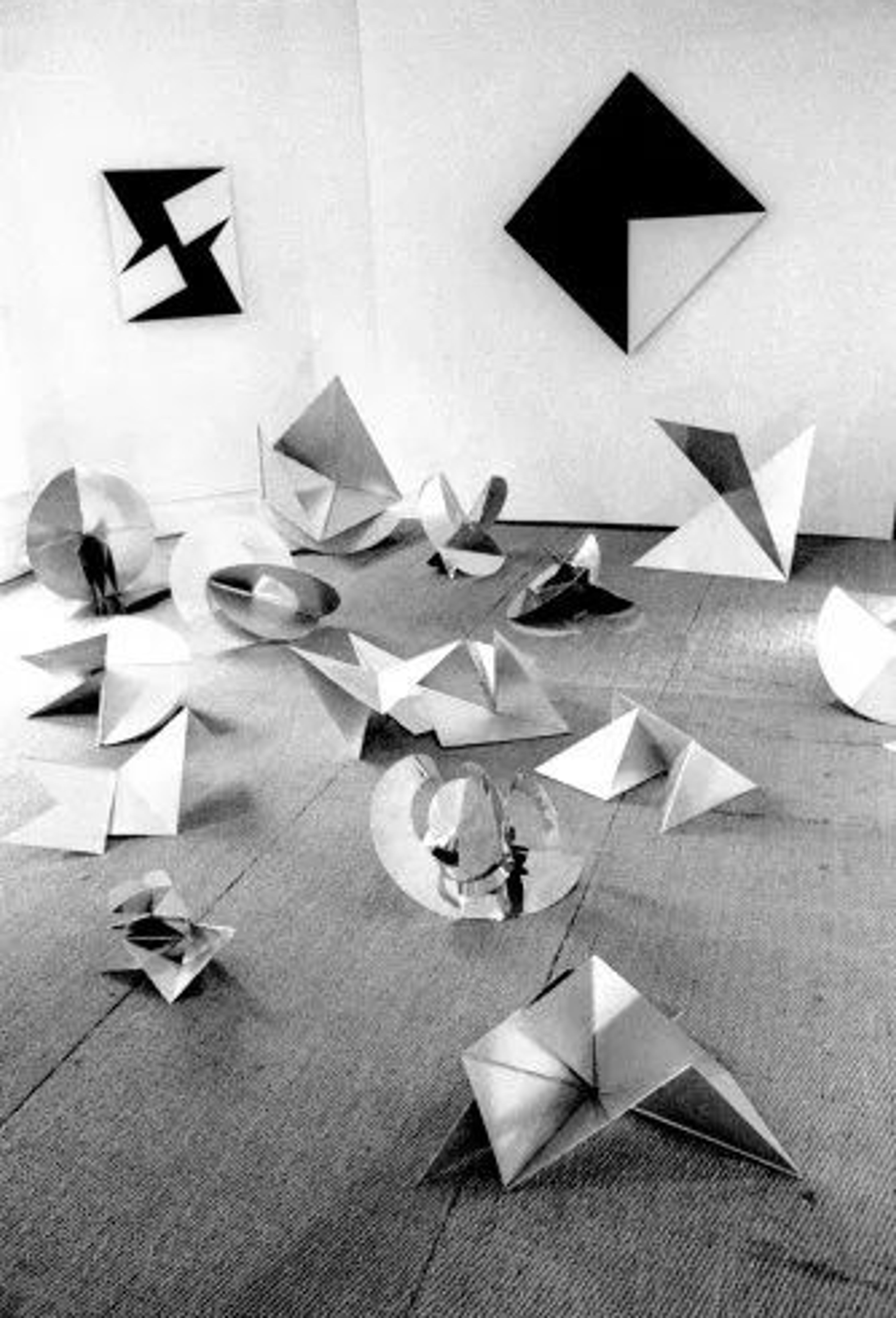 Composición de figuras geométricas plegadas en blanco y negro.