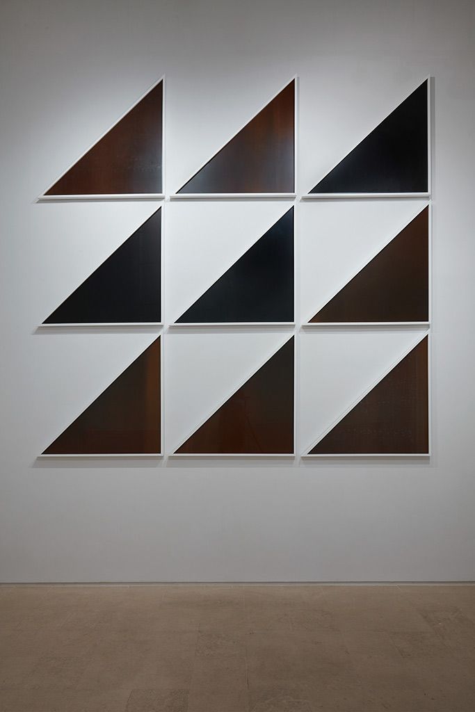 Composición de triángulos oscuros dispuestos en una cuadrícula.