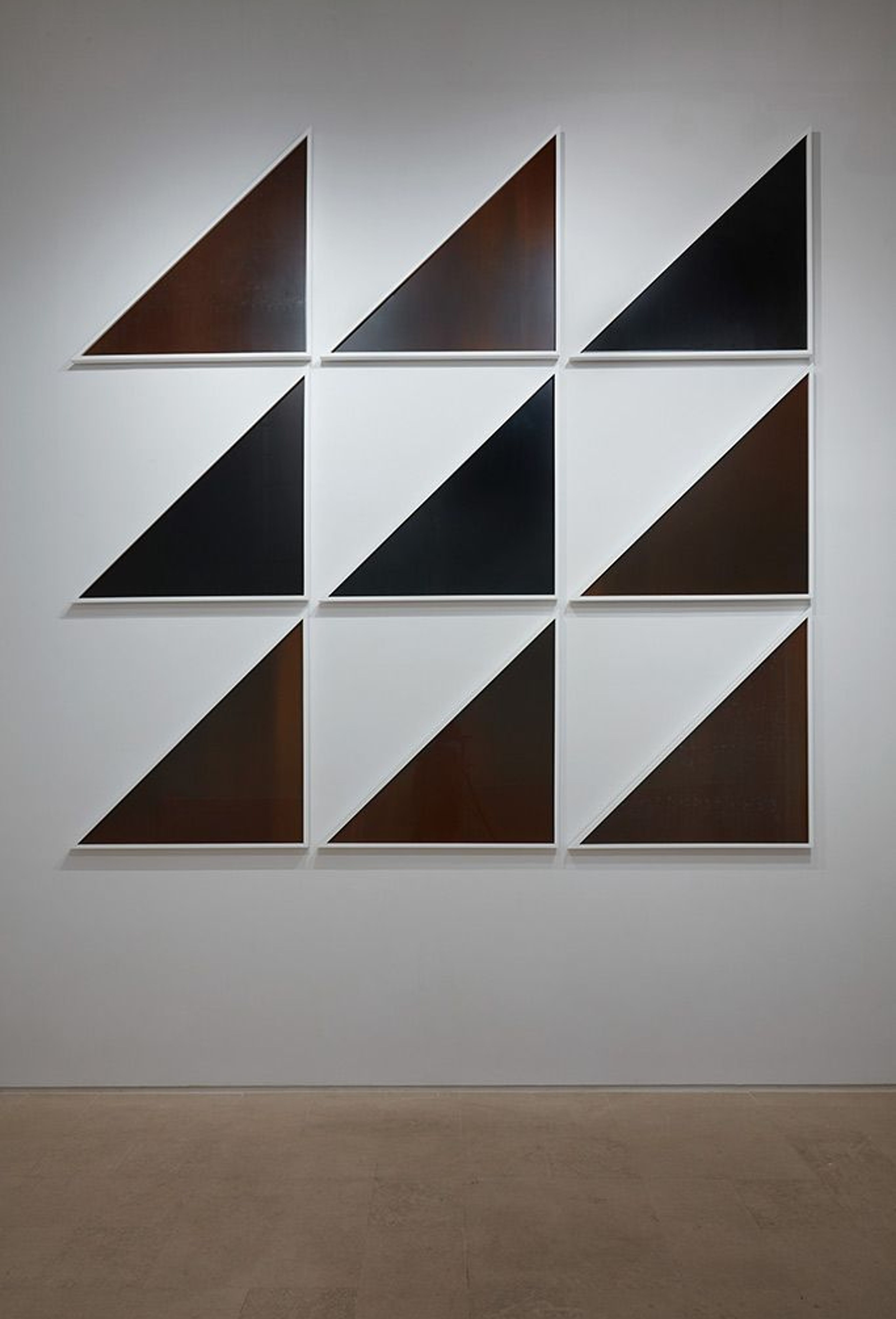 Composición de triángulos oscuros dispuestos en una cuadrícula.