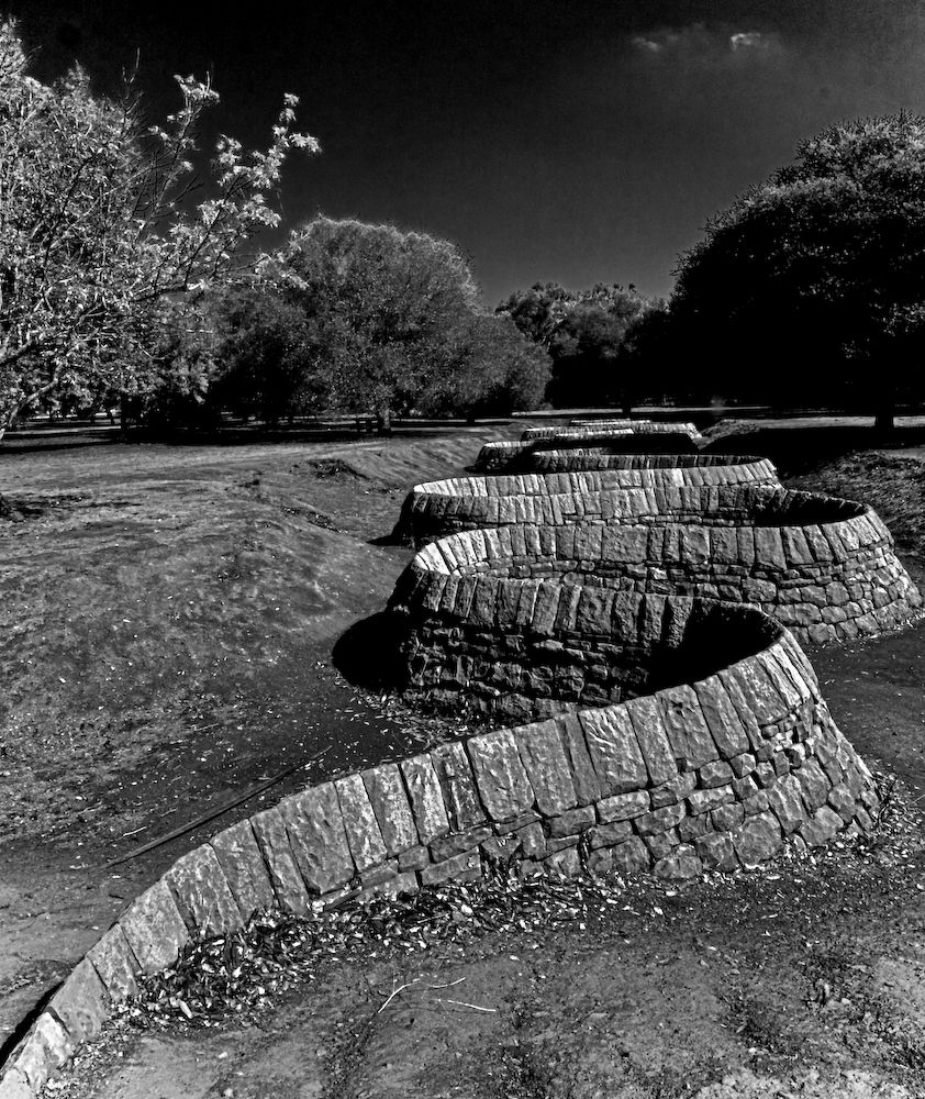 Esculturas curvas dispuestas al aire libre, fotografiadas en blanco y negro.