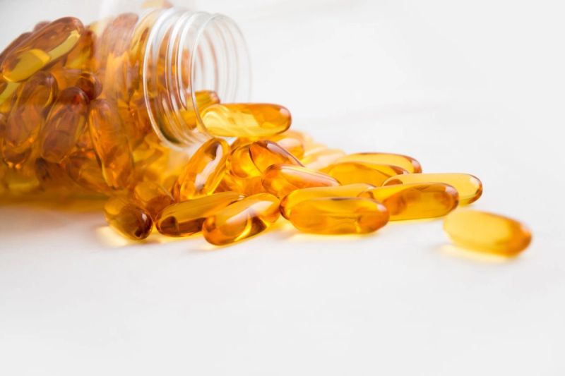 omega 3 gold pills spilling out of bottle