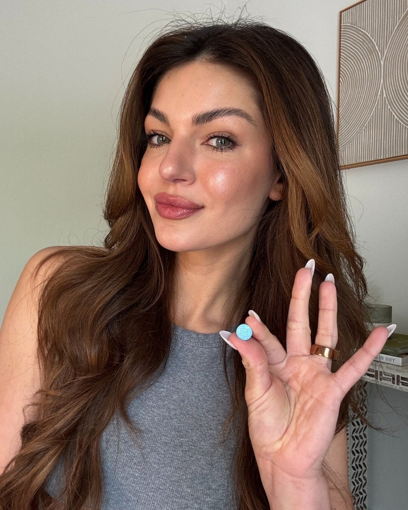 bluechew woman holding blue sublingual tablet